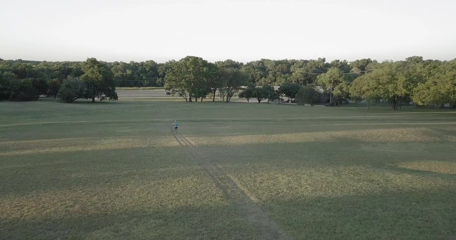 A runner jogs across a field