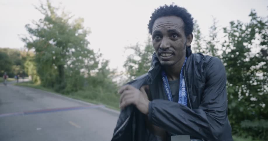 A runner puts on a jacket outside