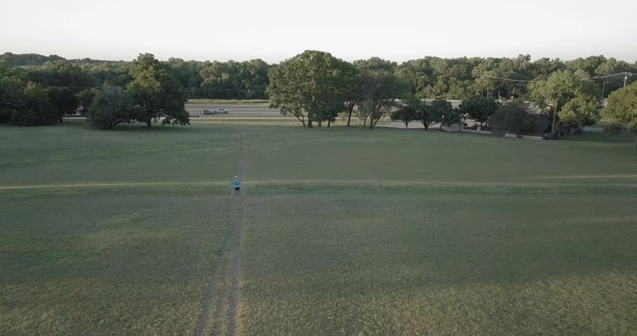 A runner jogs across a field