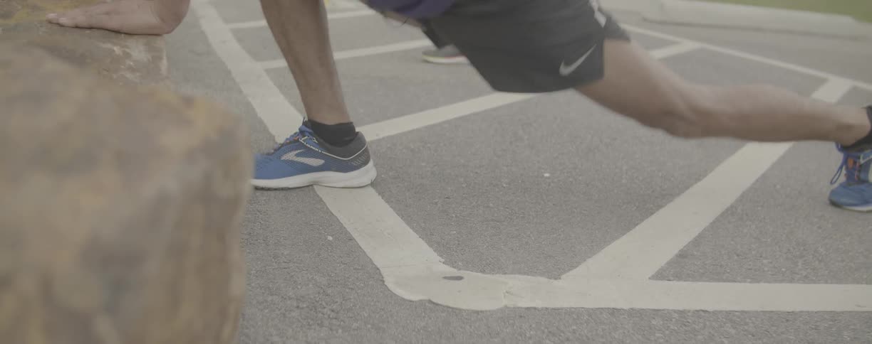 Man does lunges on the pavement
