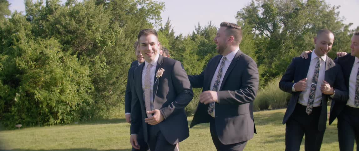 Groom with groomsmen smiling and walking