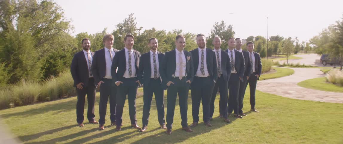 A groom poses with his groomsmen outside