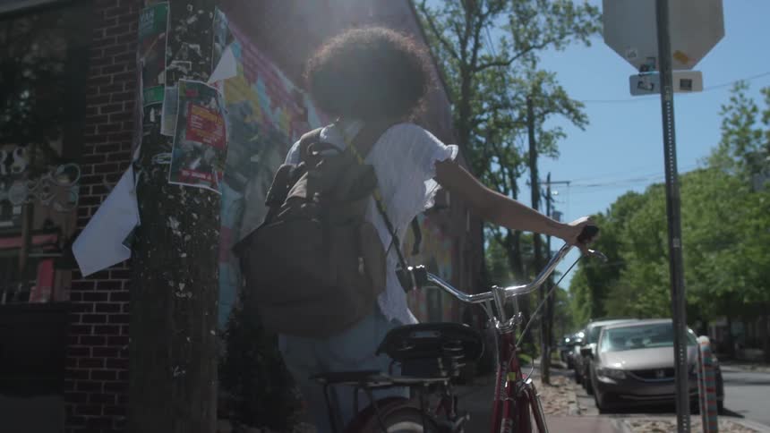 Woman walking a bicycle through the city in the afternoon
