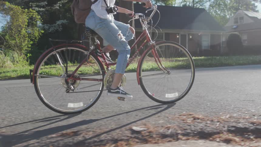 Woman rides her bike in a neighborhood on a sunny day
