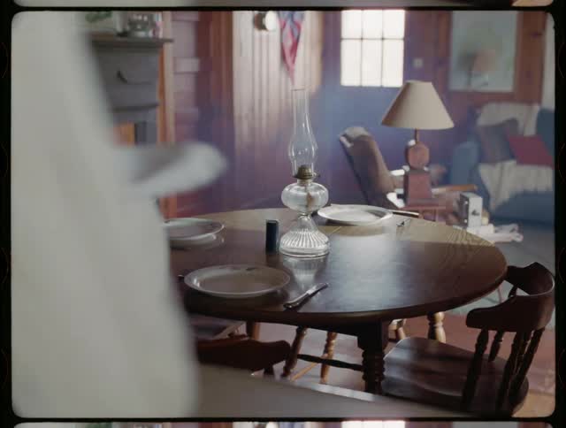 Woman is drying a plate with cloth in dining room