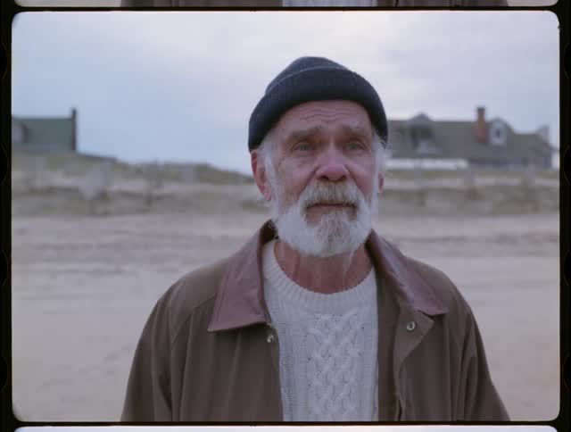 Older man is smiling and crying as he walks towards the ocean