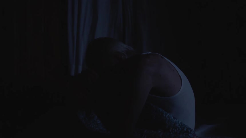 Man sitting in bed praying while it's storming