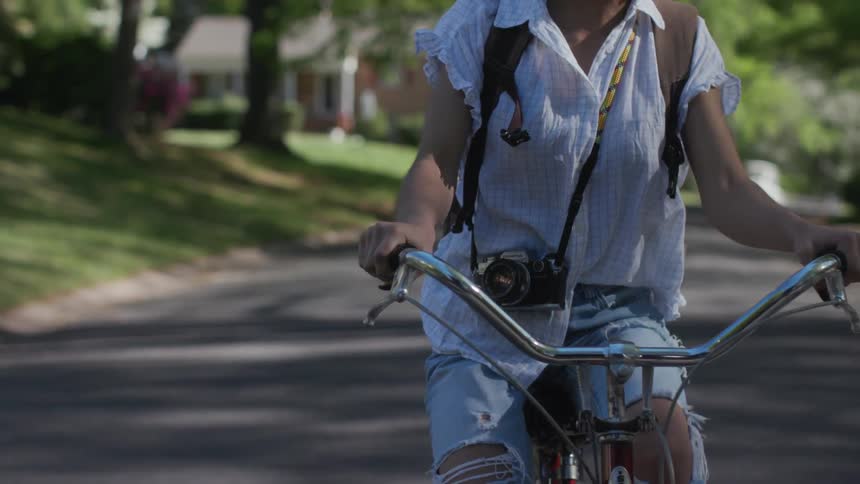 A child is riding their bicycle down the neighborhood block