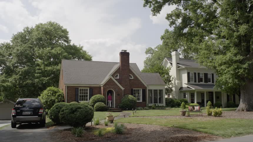 People enter the front door of a brick house