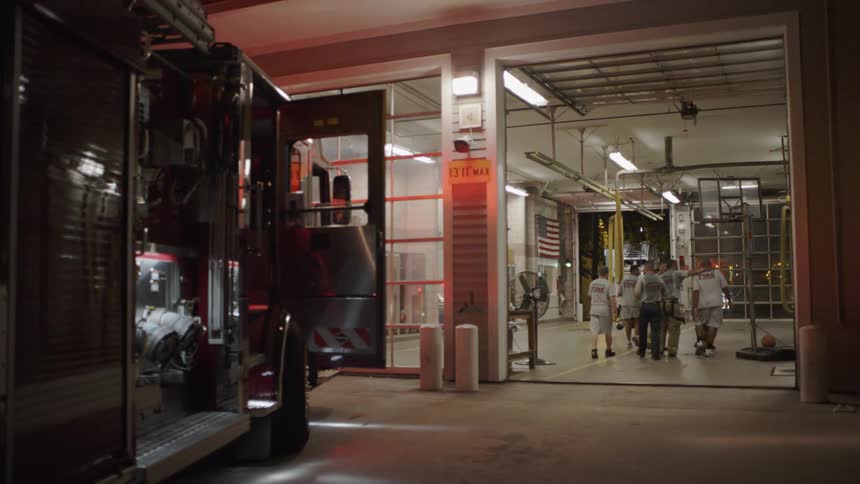 Firefighters are hugging and laughing as they return to their station at night