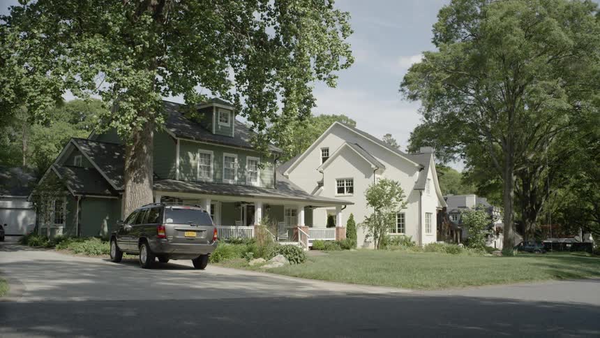 A person enters the front door of a house
