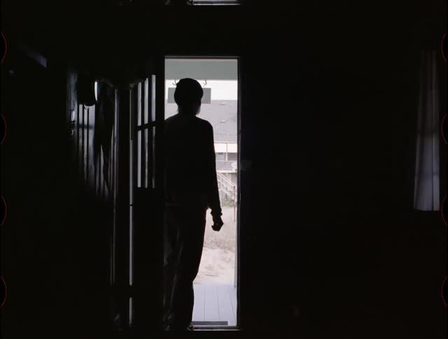 A man looks out an open front door