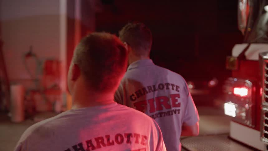Firefighters walk past truck