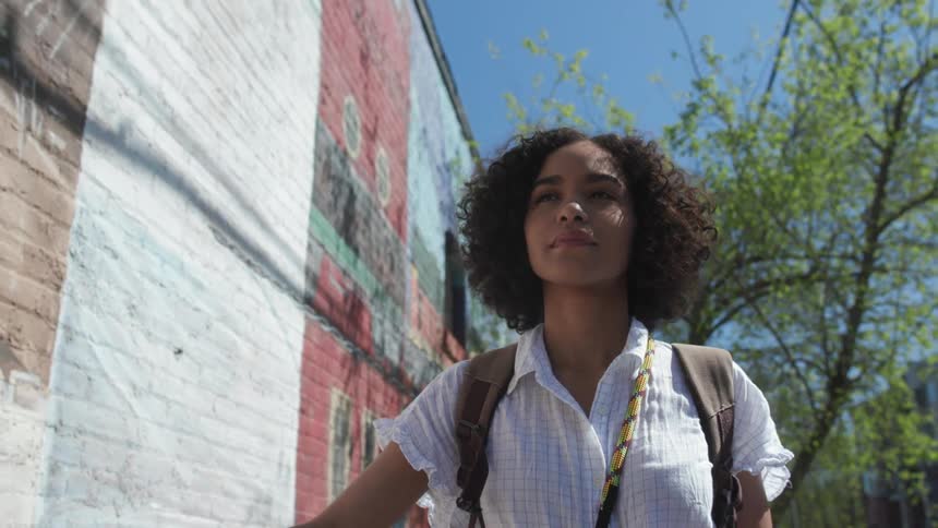 A woman walks past the building on a sunny day