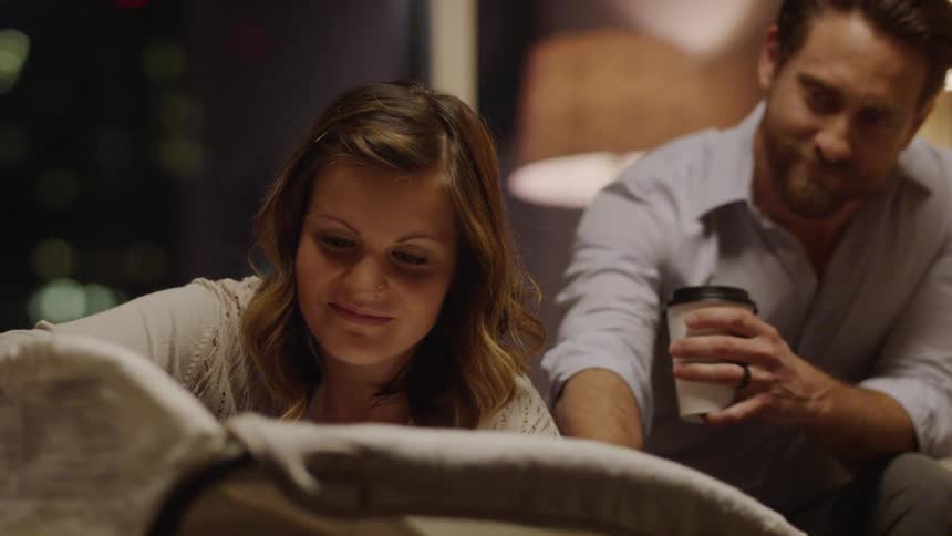 Man and woman sit gazing and smiling