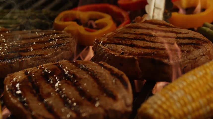 Steak and vegetables on firey barbeque grill