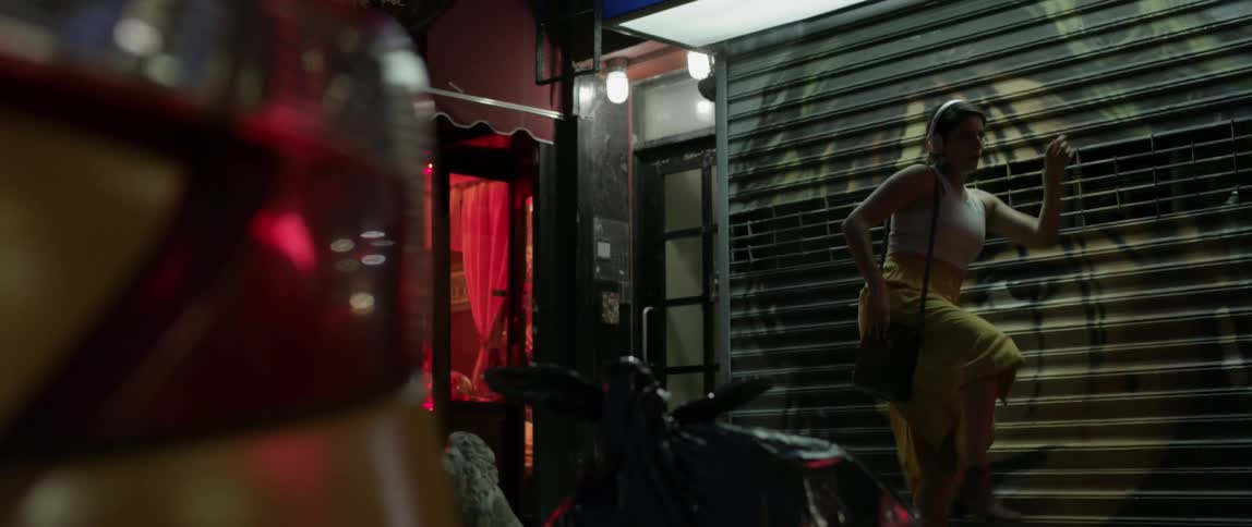 Woman dances in front of closed store at night