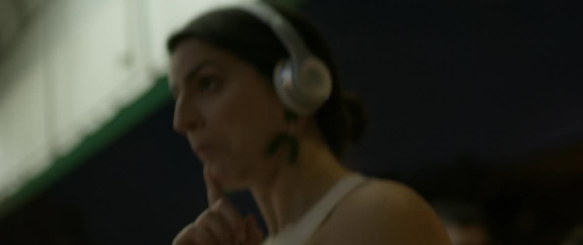 A woman dances wearing headphones at night
