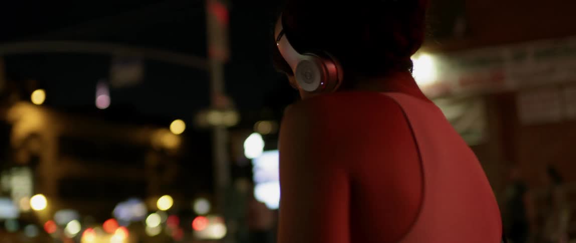A woman dances playfully outside at night