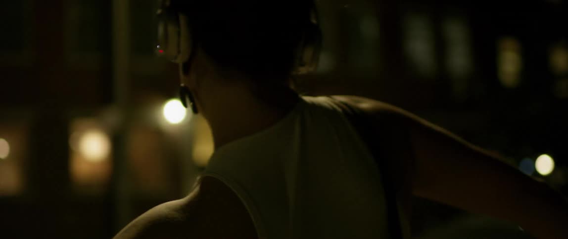 A woman dances on the street at night
