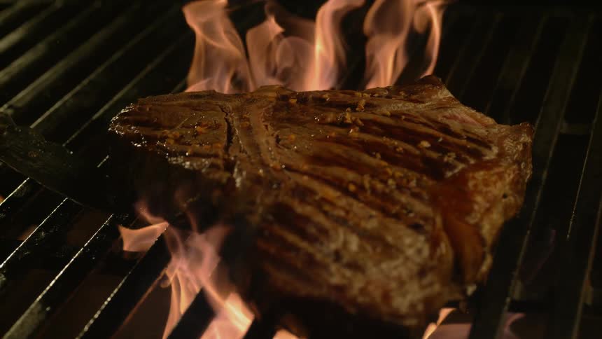 T-Bone steak on grill with flames