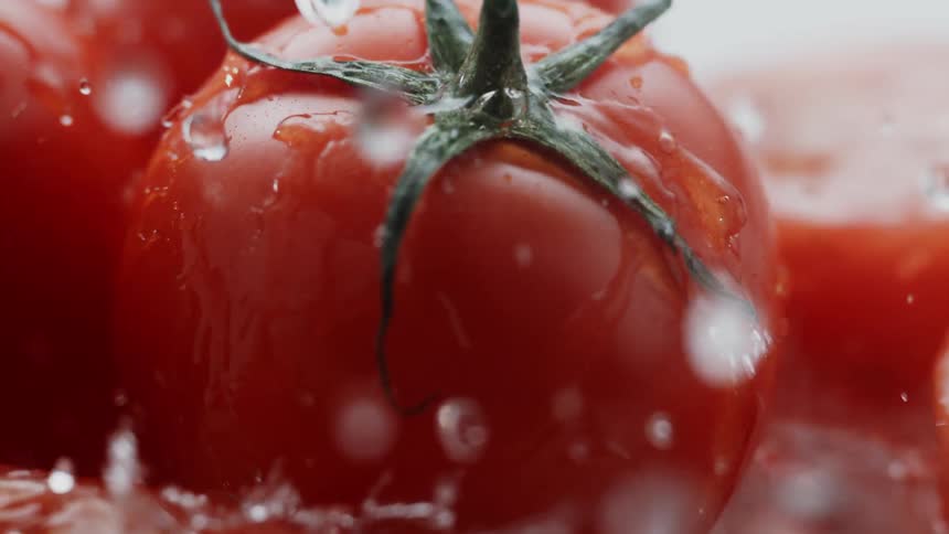 Water splashes down onto tomatoes