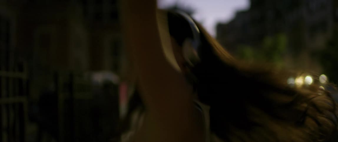 A woman dances playfully at night
