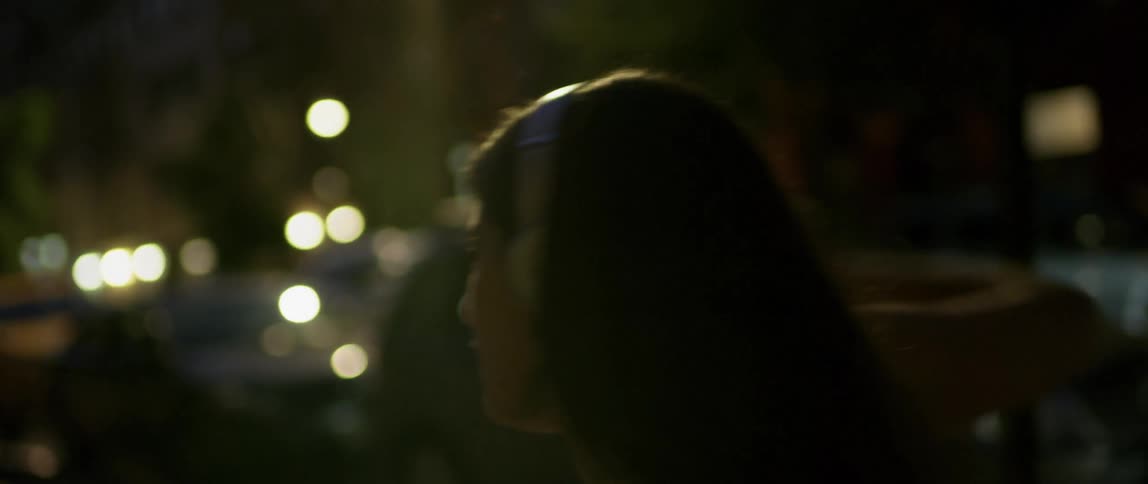 A woman dances on a city sidewalk