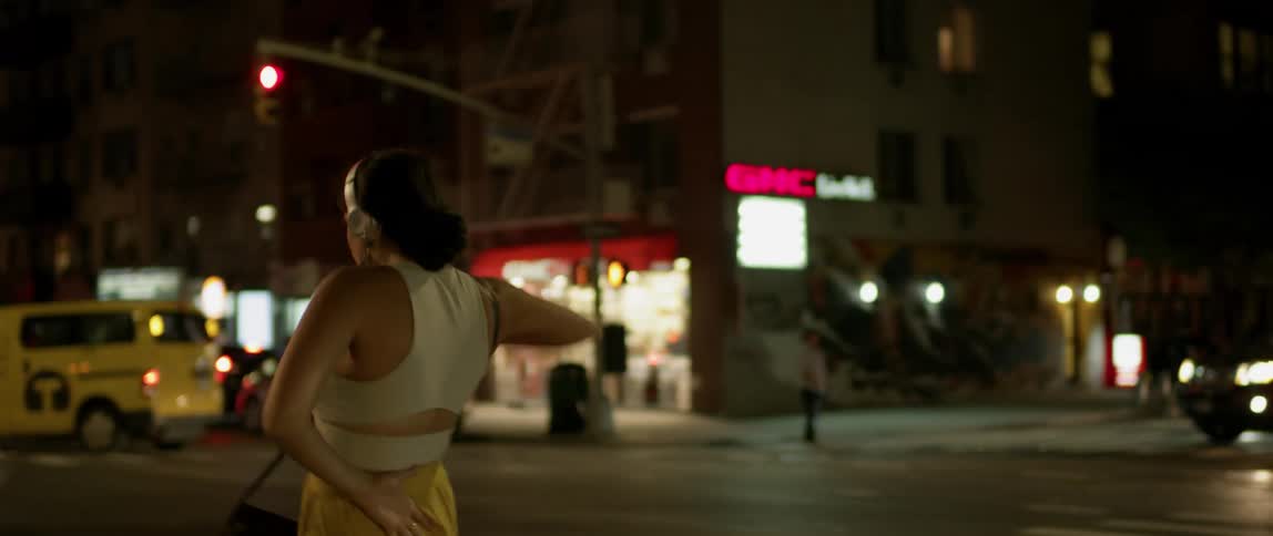 A woman dances as she crosses the street