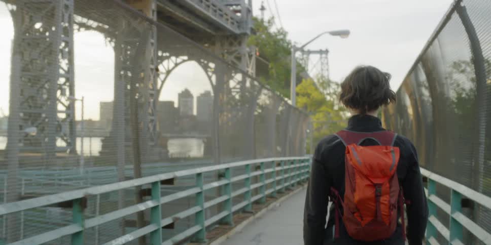 A pedestrian crosses a city bridge