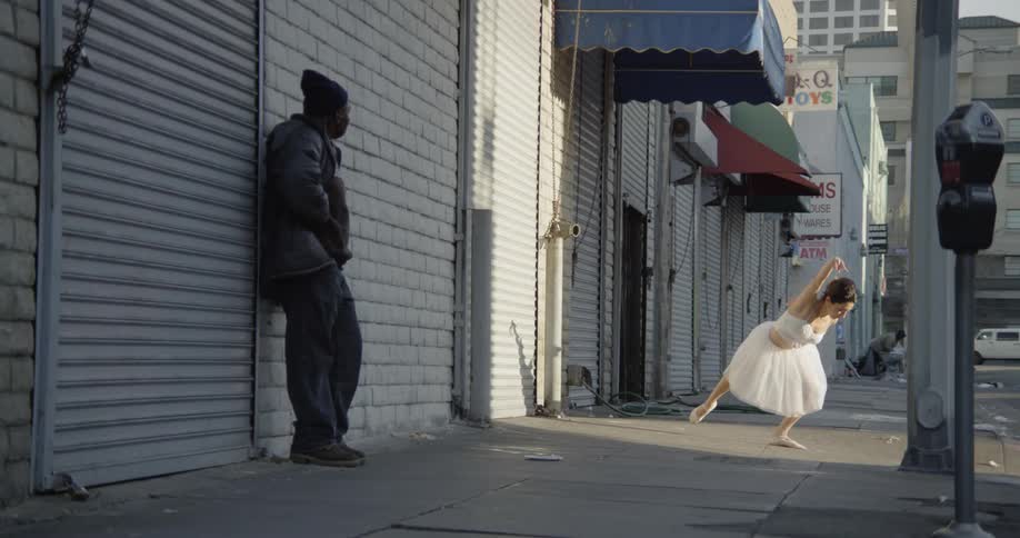 A ballet dancer dances on the sidewalk