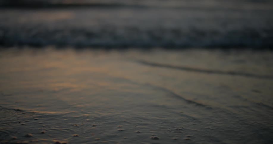 Small waves on beach at sunset shallow focus