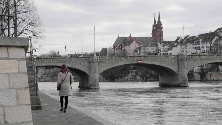 Woman Walking Along a River in Switzerland