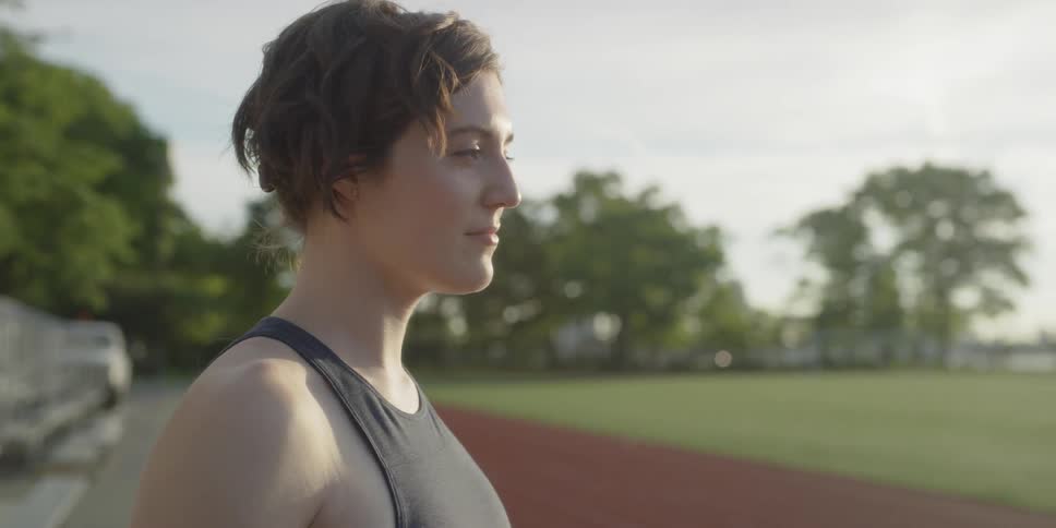 A woman stands on a clay running track