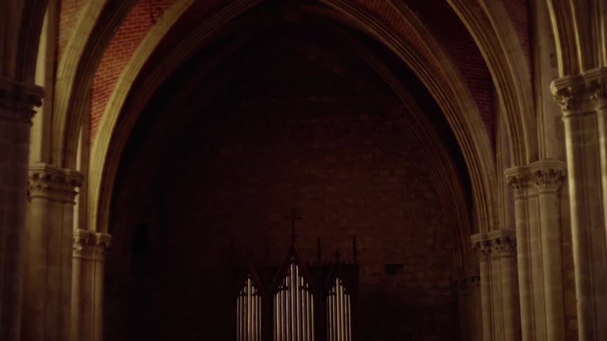 It is dark under the arches of the building