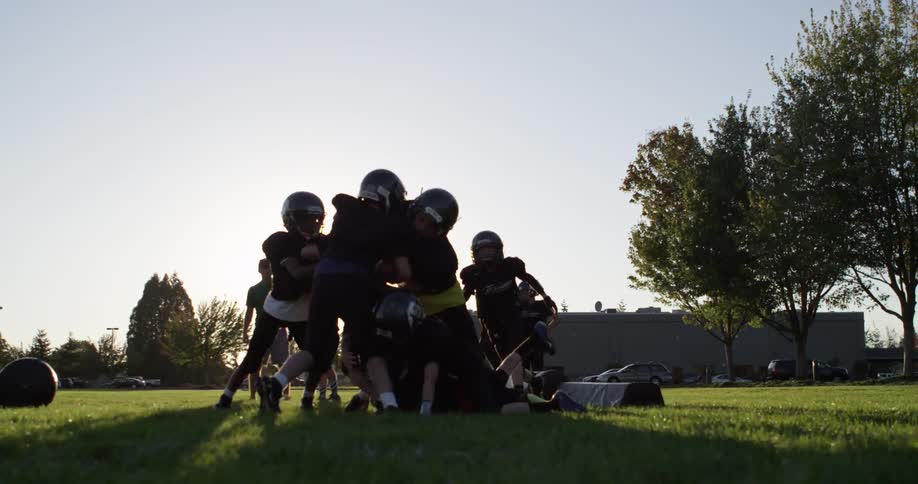 A youth football team practices in the evening