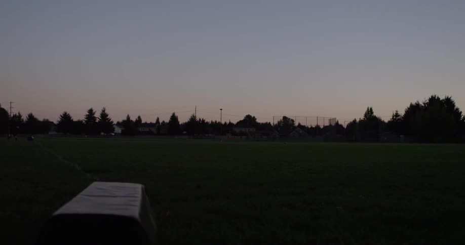 A football team runs backwards and forward in the evening