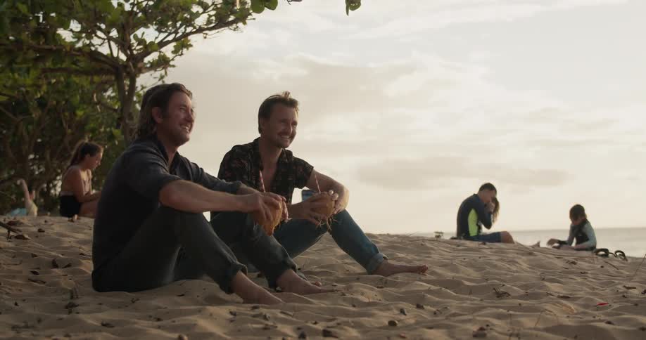 People sit on the beach talking on a cloudy day