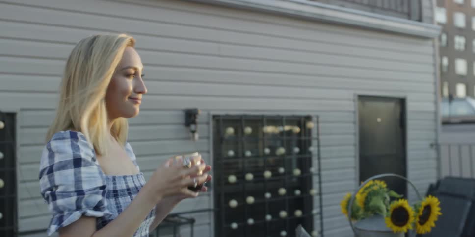 A woman takes a sip on the patio