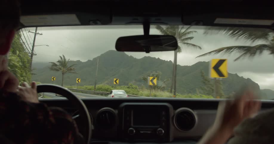 A car is driven on a mountain road on a cloudy day