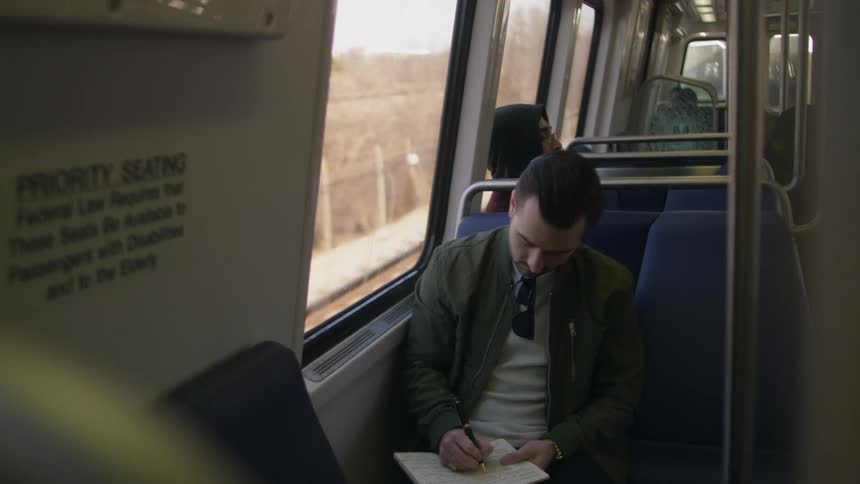 Man journals while riding public transportation