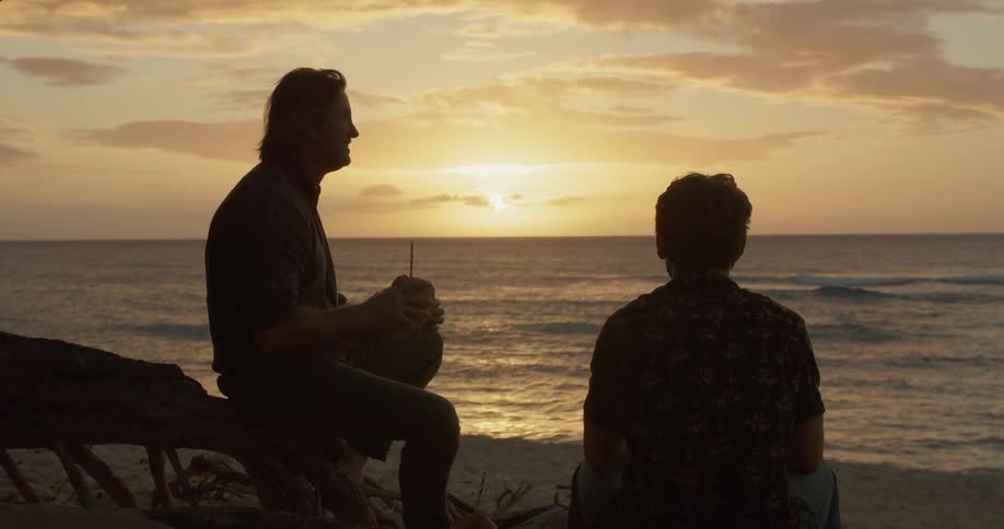 Two men drink on the beach