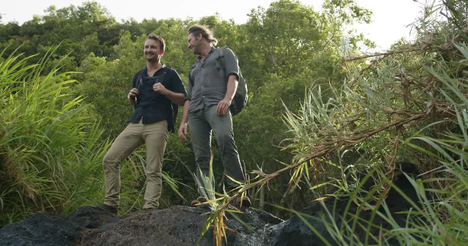 Two men talk together by the plants