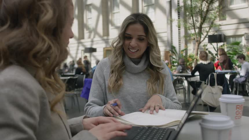 Women sitting outside talking while working