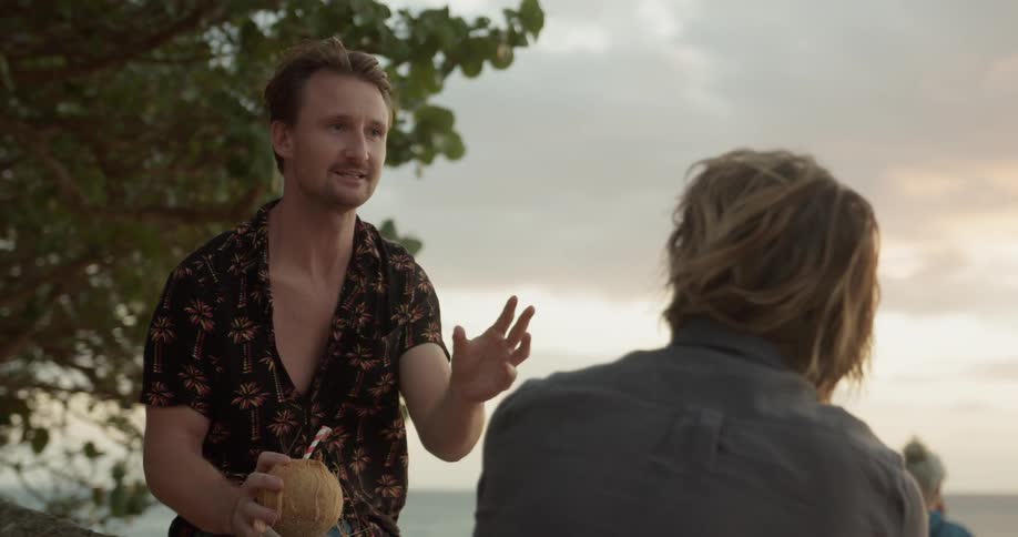 Two men talk together on the beach