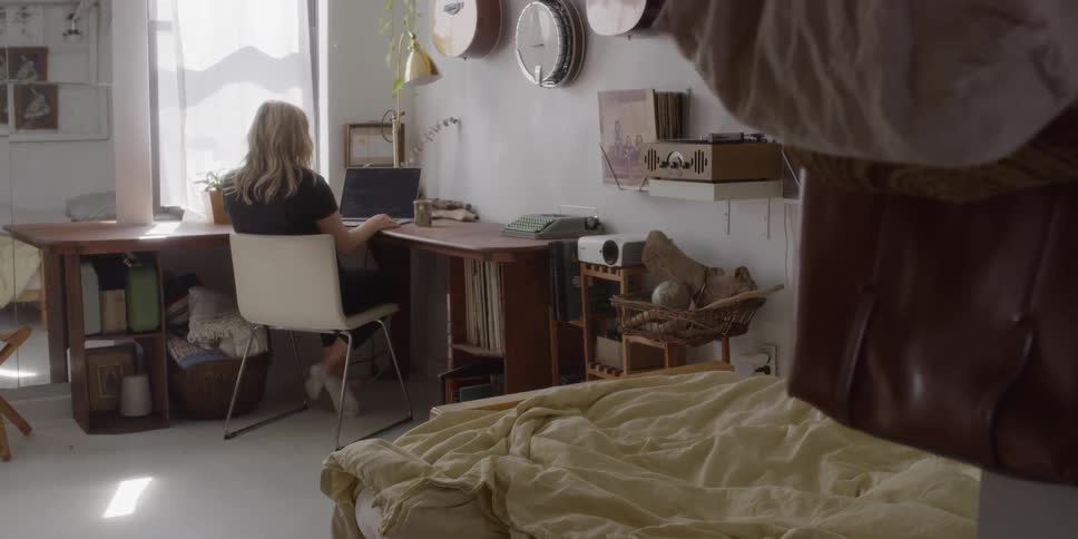 A woman sits down at her desk