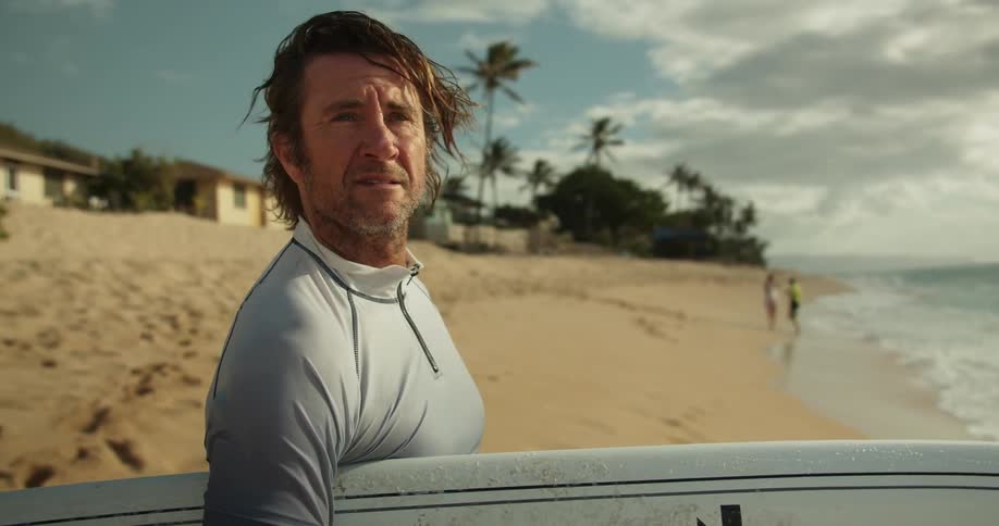 A man holds a surfboard on the beach