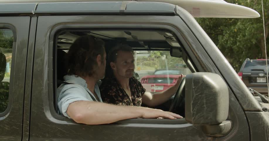 Two men in a vehicle come to a stop