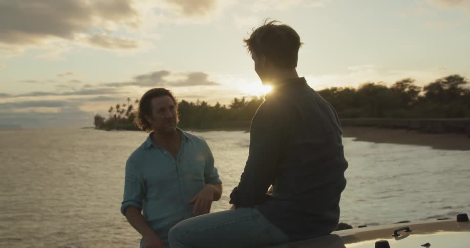 Two men talk together on the beach