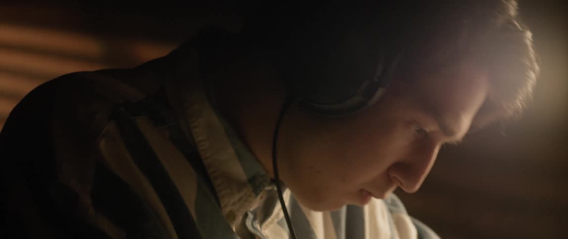 Man wears headphones as he writes